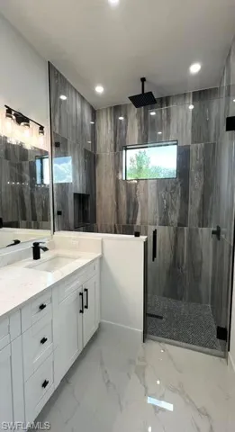 Bathroom featuring vanity and a tile shower