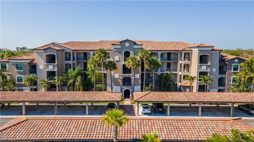 View of apartment building / complex with covered parking