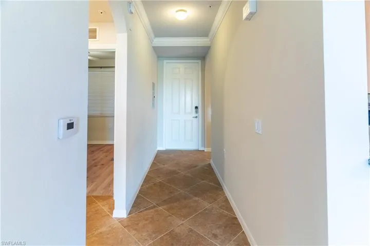 Hall featuring crown molding and light tile patterned floors