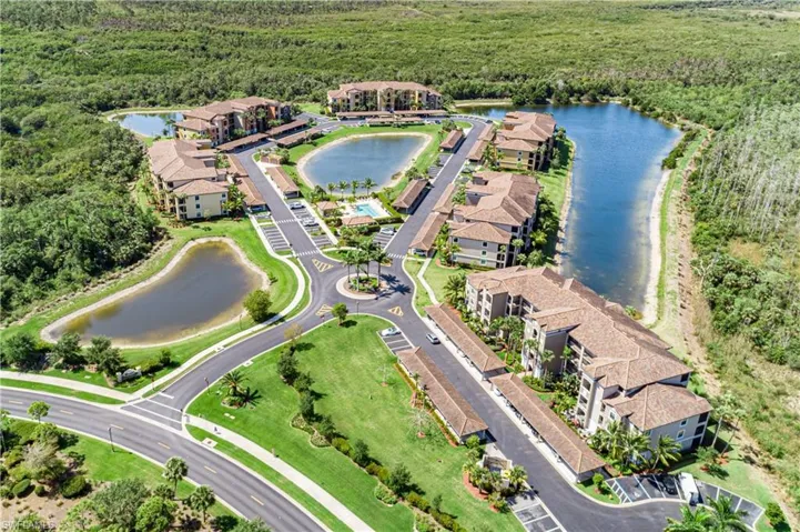 Aerial overview of property's location featuring a heavily wooded area and a large body of water
