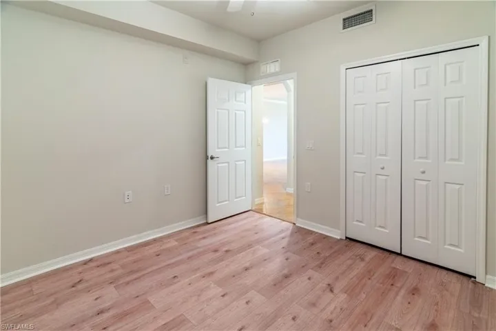 Unfurnished bedroom with light wood-style floors, ceiling fan, and a closet