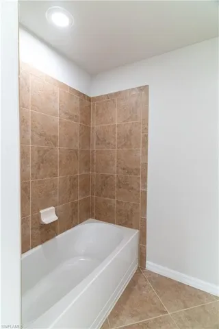Bathroom with tile patterned flooring and bathtub / shower combination