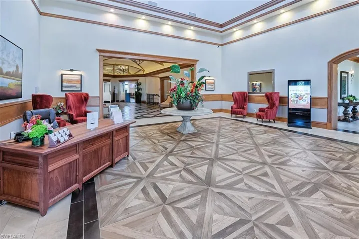 Common area featuring a high ceiling, ornamental molding, and wainscoting