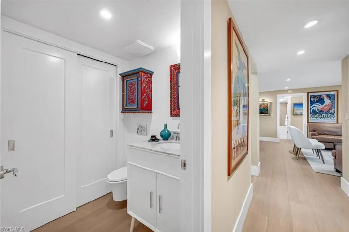 Bathroom with toilet, vanity, recessed lighting, and wood finished floors