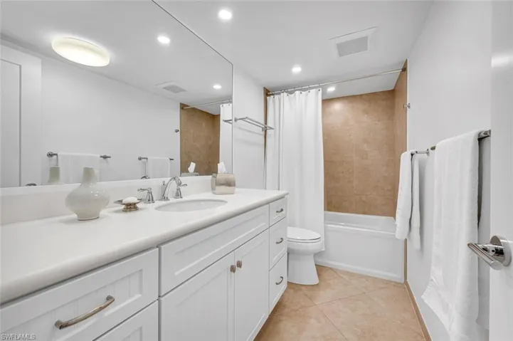 Full bath featuring tile patterned flooring, vanity, toilet, and visible vents