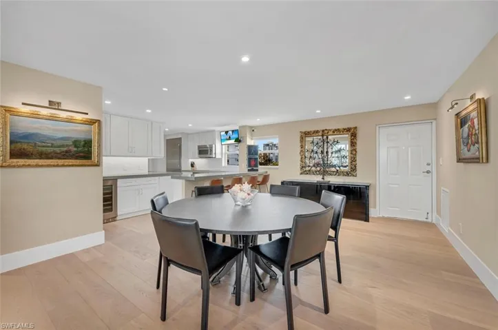 Dining room with baseboards, wine cooler, recessed lighting, and light wood finished floors