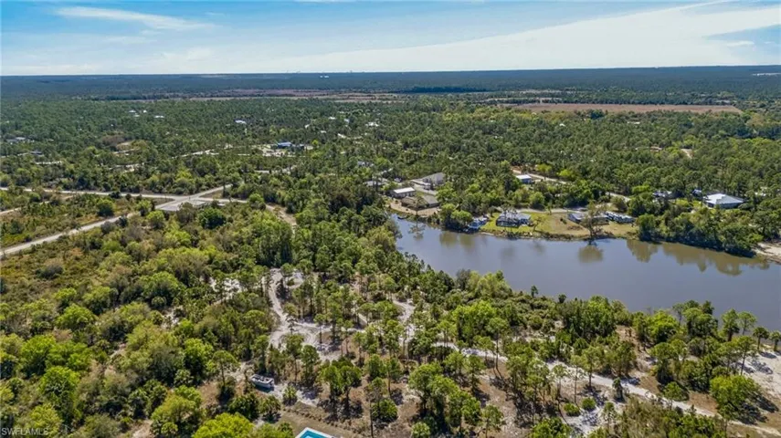 Aerial view of a heavily wooded area and a nearby body of water
