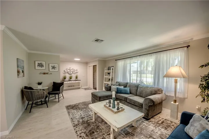 Living room featuring ornamental molding and light hardwood / wood-style flooring