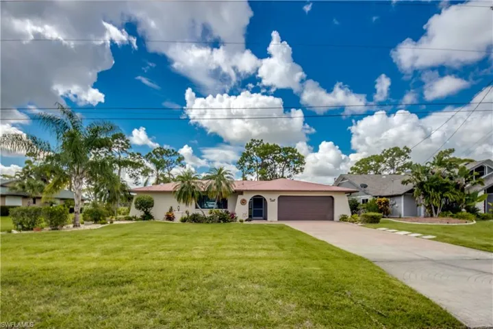 Single story home featuring a front lawn and a garage