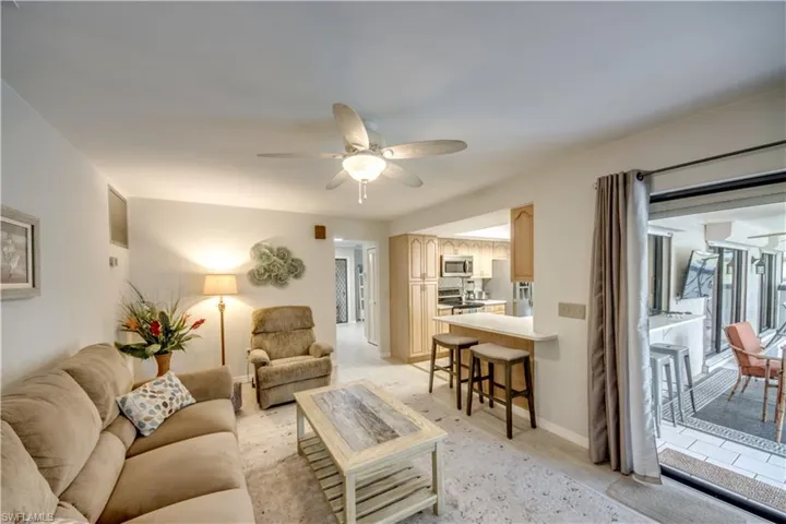 Living room featuring light tile flooring and ceiling fan