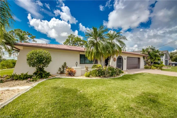View of front of house featuring a front lawn and a garage
