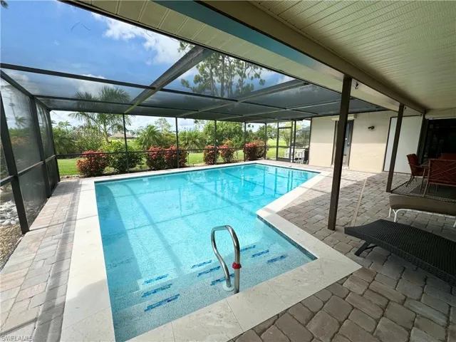View of pool with a patio and a lanai