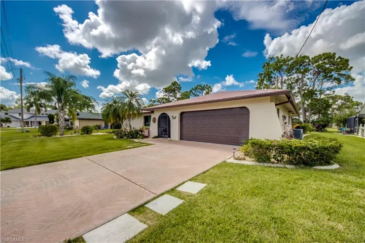 Ranch-style home with central AC, a front lawn, and a garage