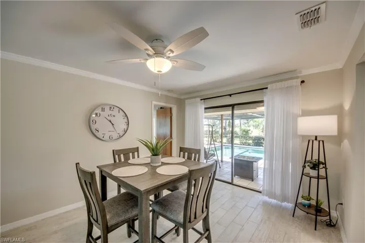Dining space featuring light wood-type flooring, crown molding, and ceiling fan
