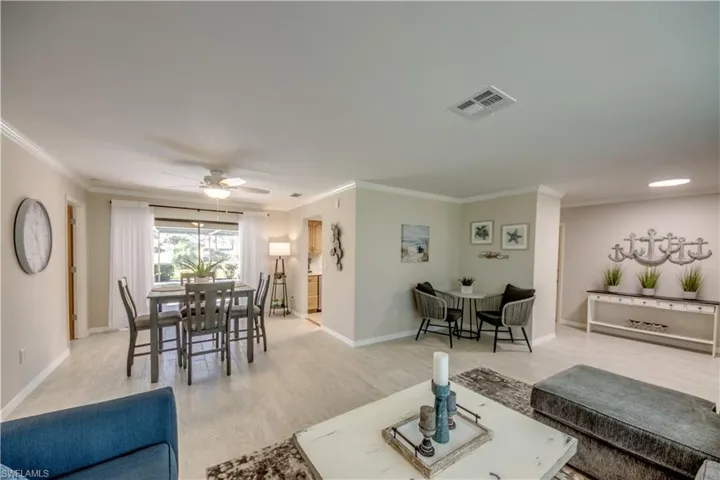 Living room featuring ceiling fan, light hardwood / wood-style floors, and crown molding