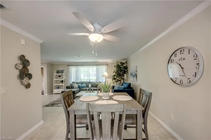 Dining room featuring ornamental molding, ceiling fan, and light hardwood / wood-style flooring