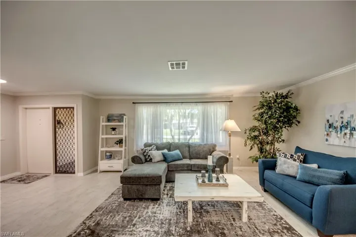 Living room featuring wood-type flooring and ornamental molding