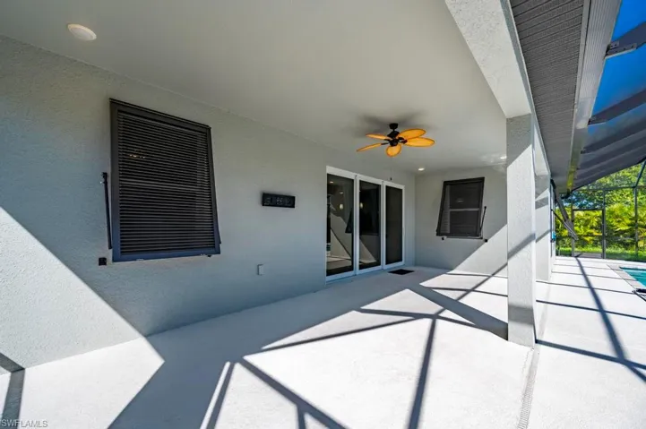 Covered patio featuring a neutral concrete finish, recessed lighting, a ceiling fan, and sliding glass door access, all enclosed by a screened structure