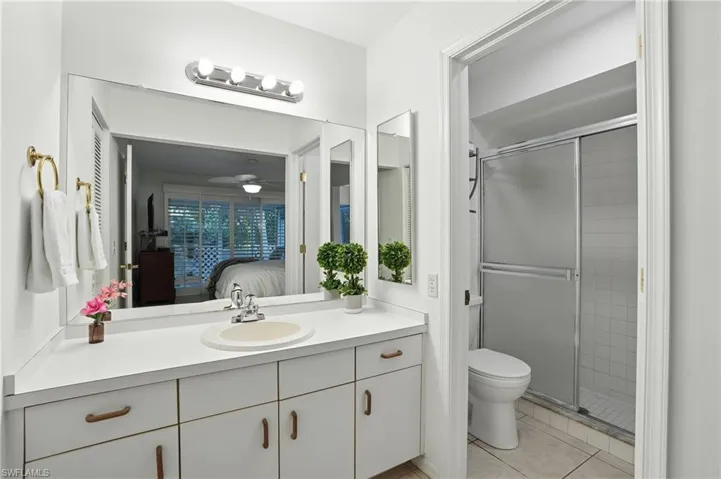 Ensuite bathroom featuring vanity, a shower stall, and tile patterned floors