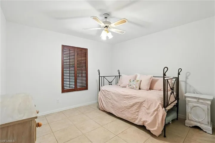 Bedroom with light tile patterned floors and ceiling fan