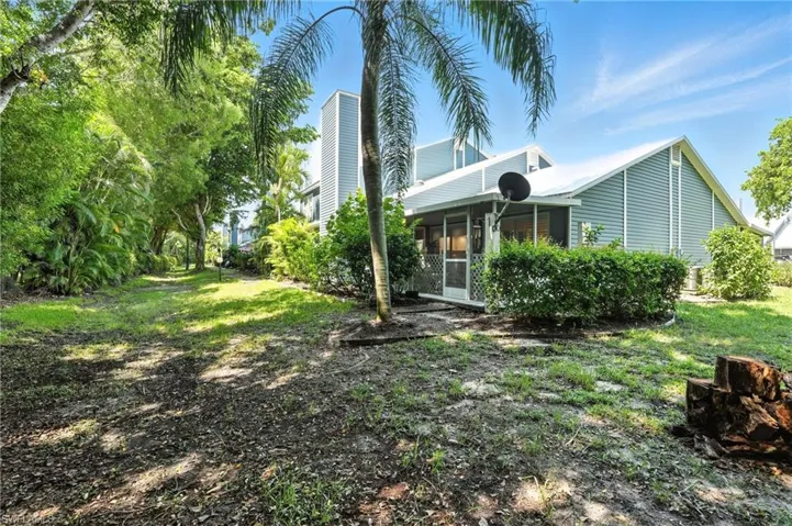 Rear view of property featuring a sunroom and a chimney