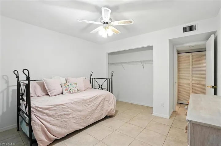 Bedroom featuring light tile patterned floors, a closet, and a ceiling fan