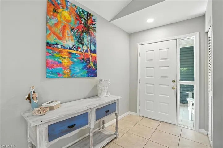 Entrance foyer featuring light tile patterned flooring and vaulted ceiling