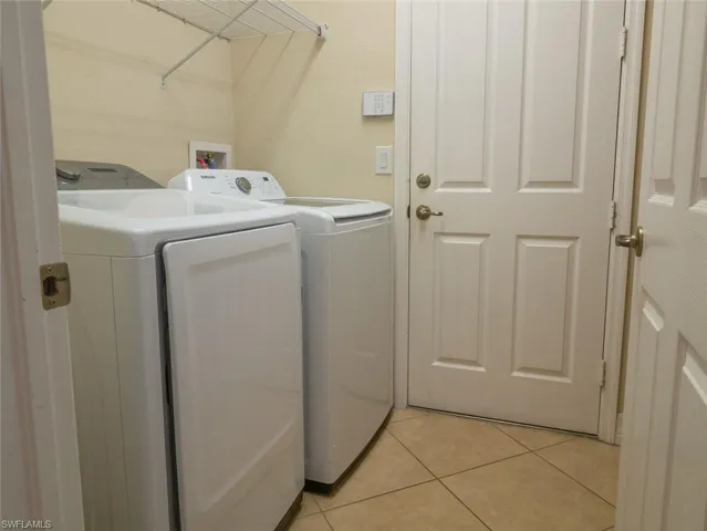Laundry area featuring washer and clothes dryer and light tile patterned floors