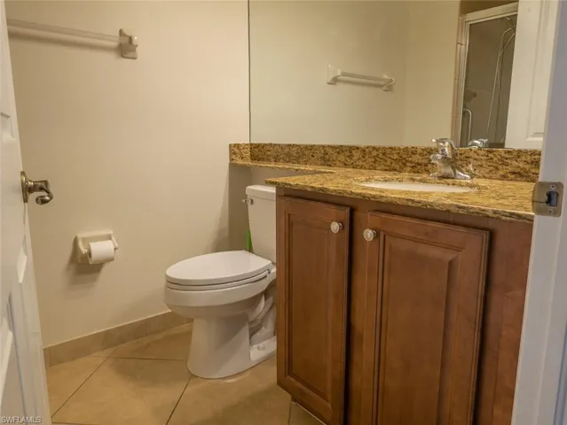 Bathroom with vanity, light tile patterned floors, and a shower stall
