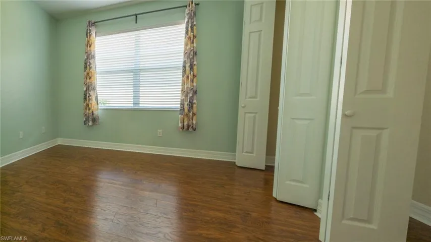 Unfurnished bedroom with dark wood-type flooring and a closet