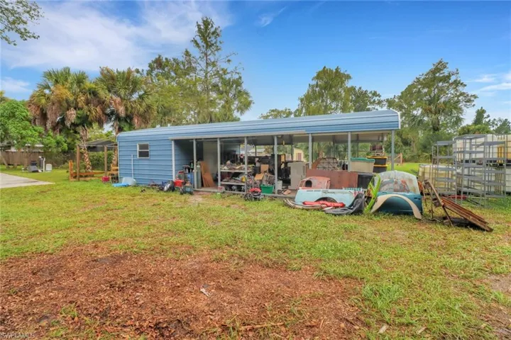 Rear view of property with a playground and a lawn