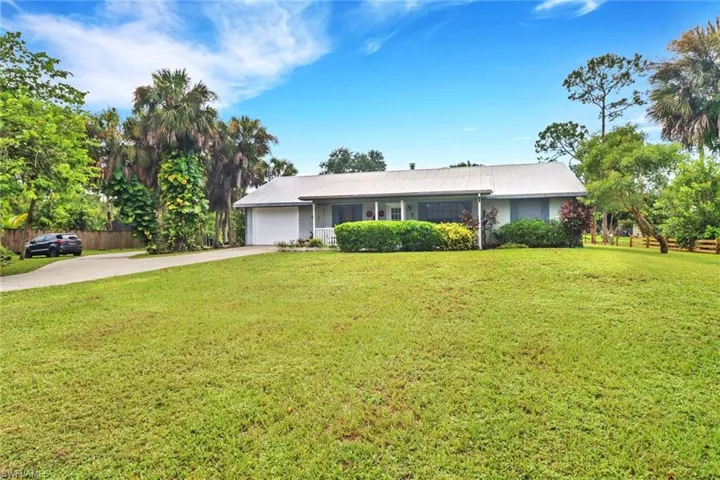 Single story home featuring a garage and a front lawn