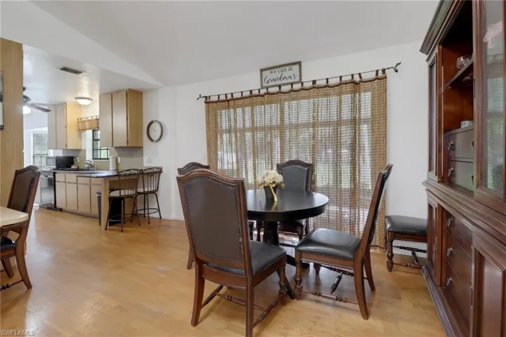 Dining area with ceiling fan, vaulted ceiling, light hardwood / wood-style flooring, and sink