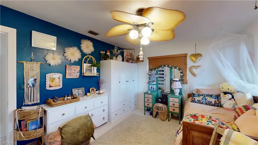 Bedroom with light colored carpet and ceiling fan