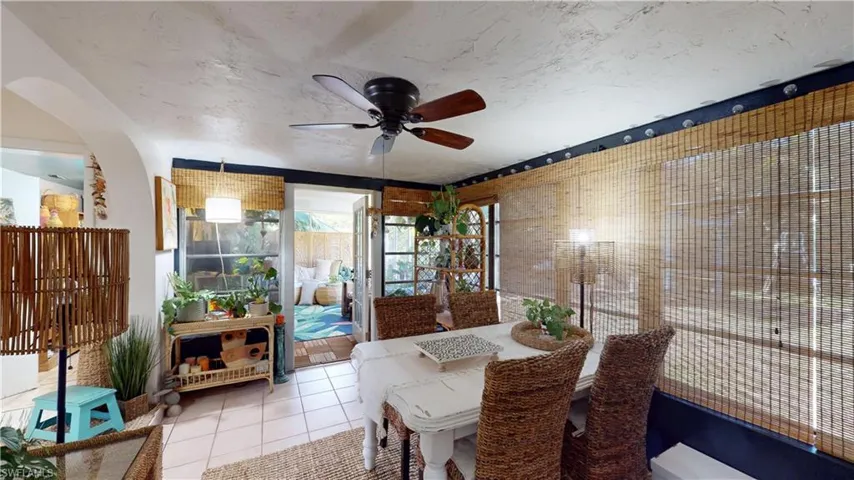 Dining area featuring ceiling fan, tile patterned floors, and a textured ceiling
