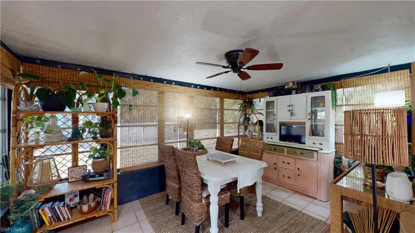 Dining room featuring ceiling fan, a textured ceiling, and light tile patterned floors