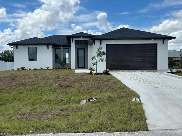 View of front of house featuring a garage and a front yard