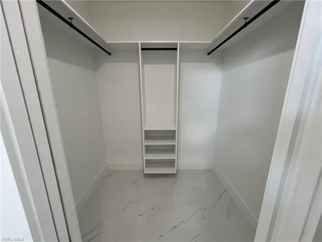 Walk in closet with light tile patterned floors
