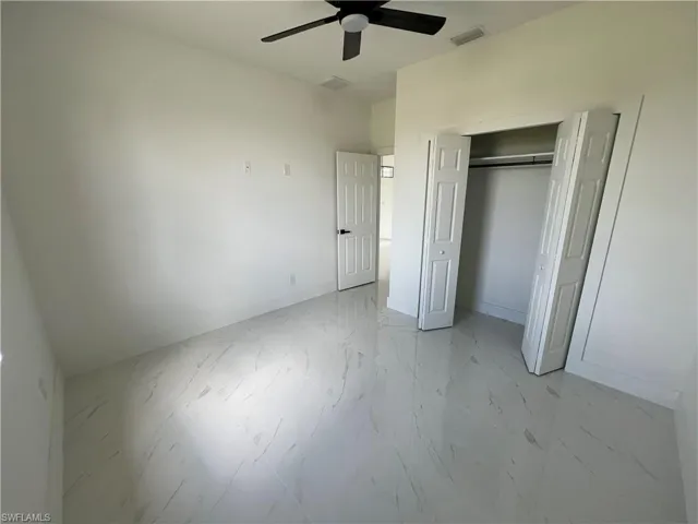 Unfurnished bedroom featuring light tile patterned floors, ceiling fan, and a closet