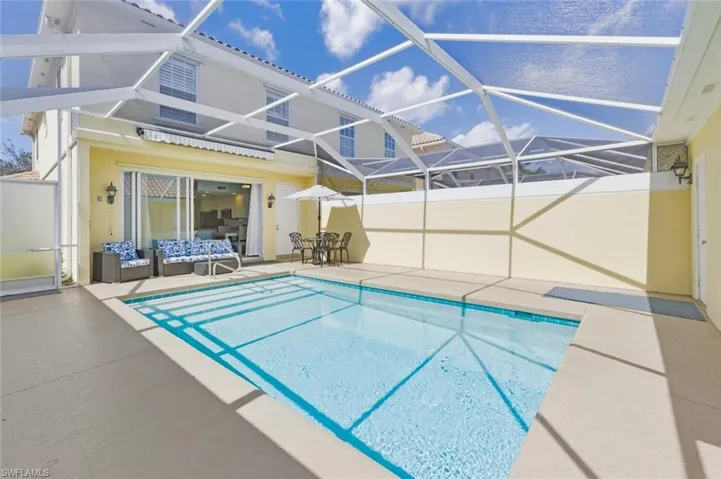 Swimming pool with a patio area, a sunroom, and glass enclosure