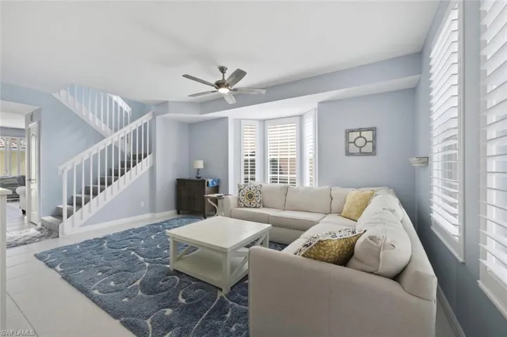 Living area featuring healthy amount of natural light, ceiling fan, and tile patterned floors