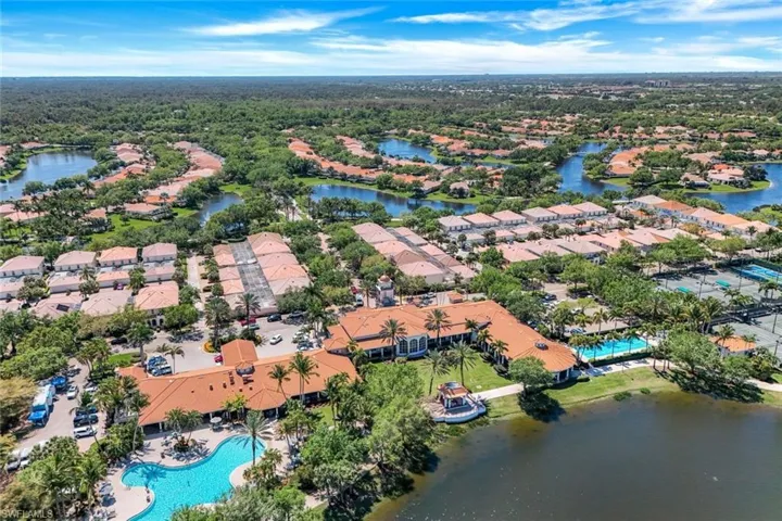 Aerial view of residential area featuring a pool area and a large body of water