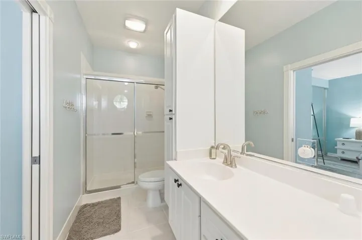 Bathroom with vanity, a stall shower, and light tile patterned floors