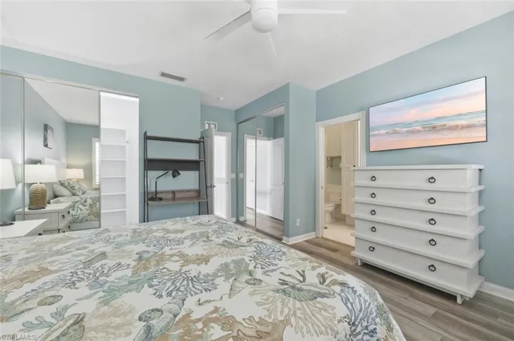 Bedroom with connected bathroom, a closet, light wood-style flooring, and ceiling fan