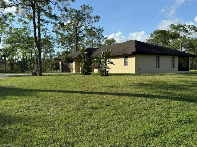 View of side of home featuring a lawn