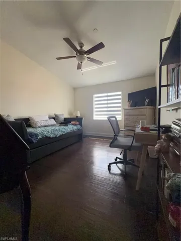 Bedroom with a desk, dark wood-type flooring, and ceiling fan