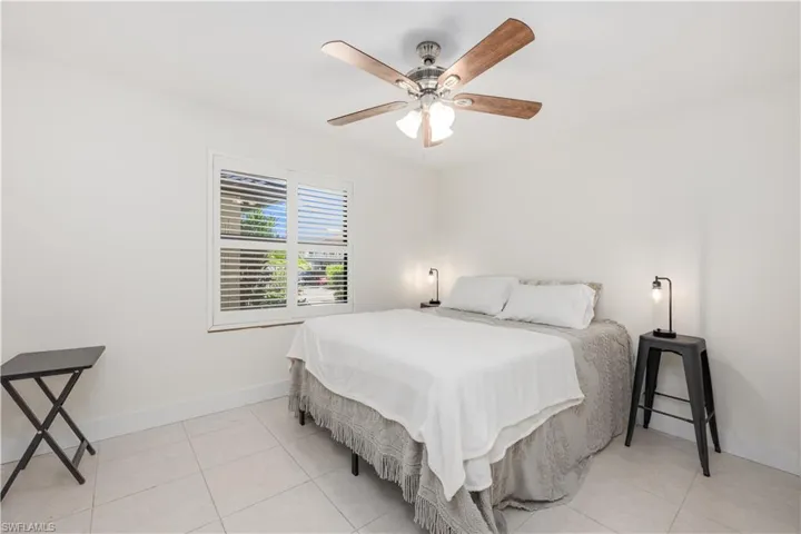 Tiled bedroom featuring ceiling fan
