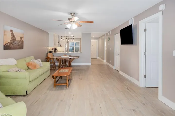 Living room with light wood-type flooring and ceiling fan