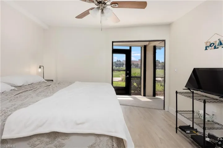 Bedroom with access to exterior, ceiling fan, and light hardwood / wood-style floors