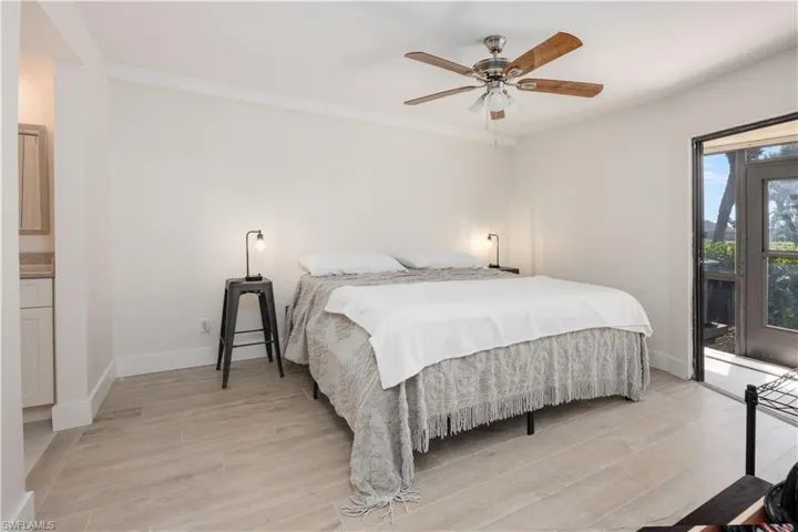 Bedroom featuring light hardwood / wood-style flooring, ceiling fan, and access to exterior